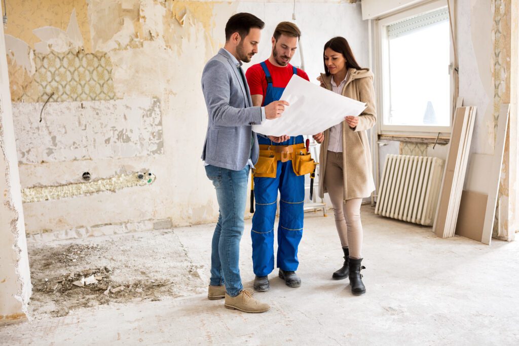 A group of people standing around looking at plans.