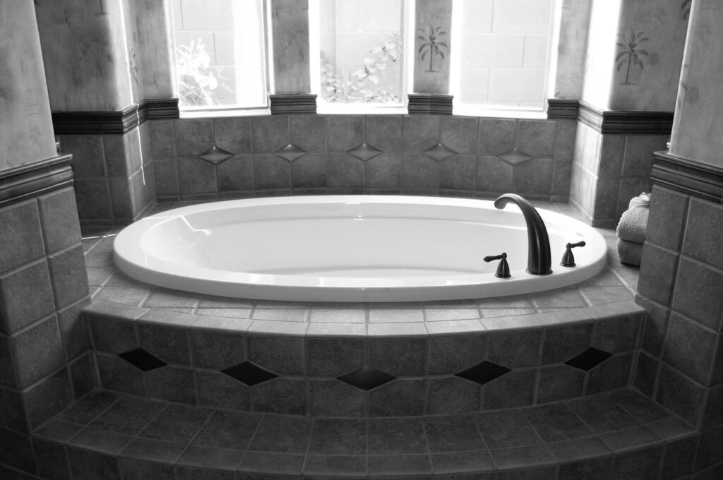 Elegant tiled bathroom with oval bathtub.