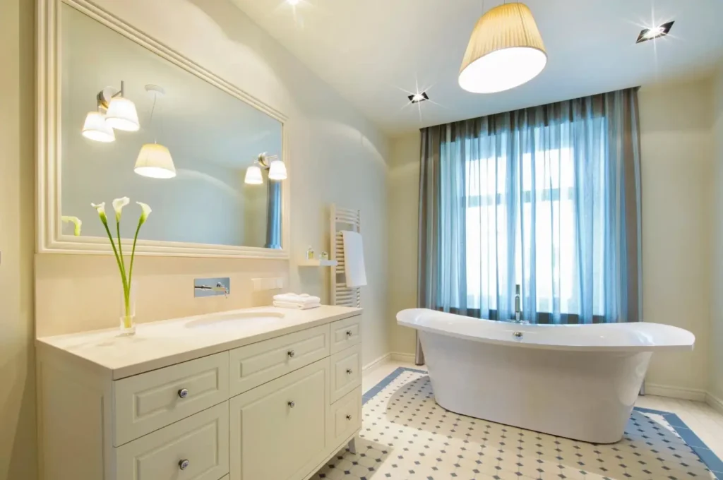Modern bathroom with bathtub and large mirror.