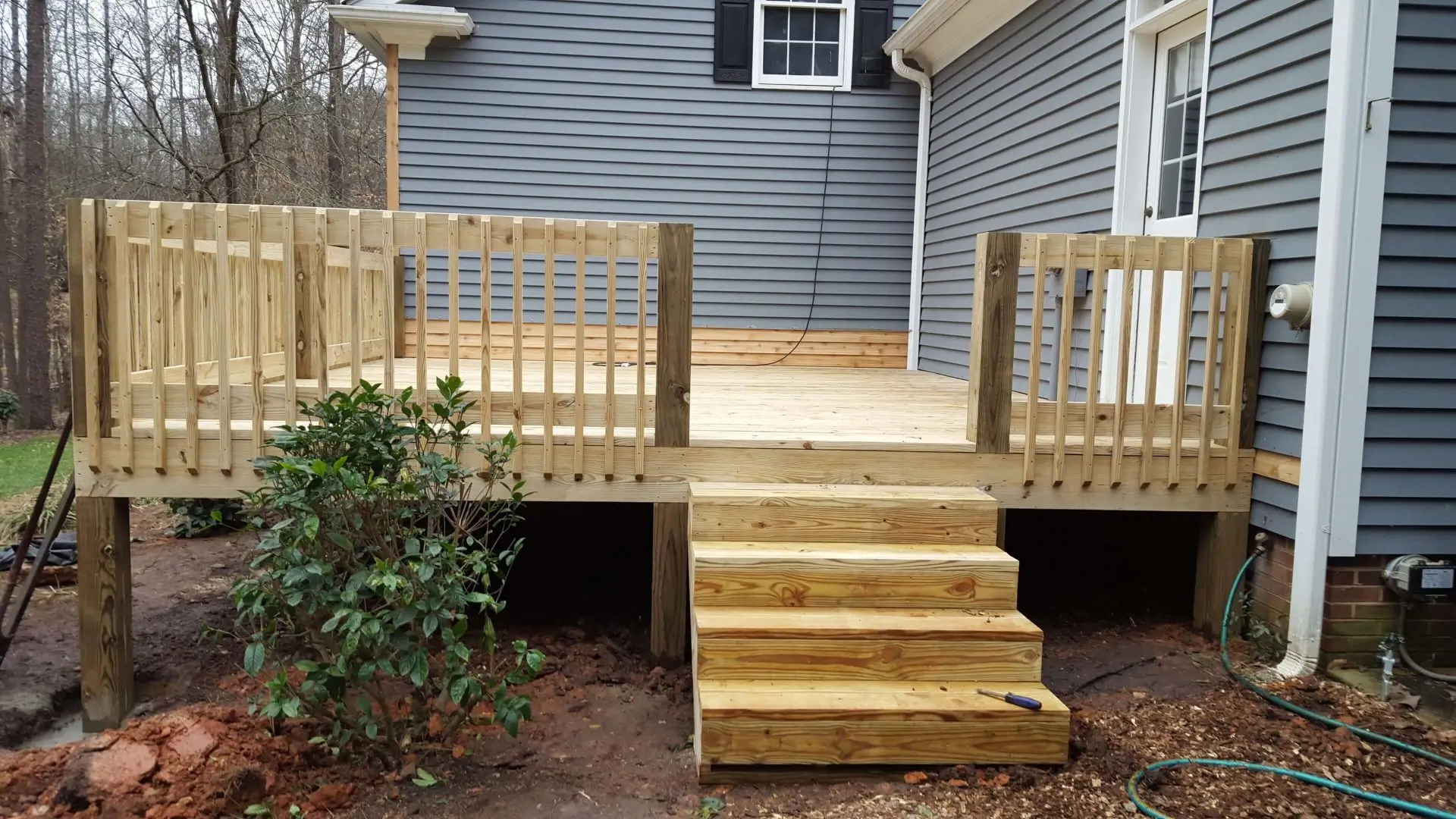 A wooden deck with steps leading to the back of it.